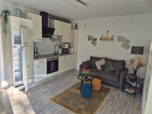 a living room with a couch and a kitchen at Evia Ferienwohnung in Heimbach