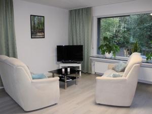 a living room with two chairs and a television at Ferienwohnung Möhneblick in Möhnesee