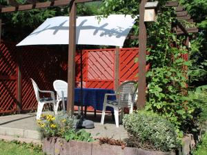 a patio with two chairs and a table with an umbrella at Ferienwohnung Möhneblick in Möhnesee