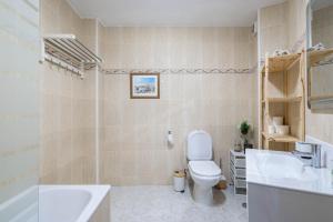 a bathroom with a toilet and a sink and a tub at Primera línea de playa Cabo Cruz in Boiro +15 photos