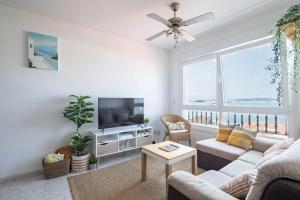 a living room with a couch and a tv at Primera línea de playa Cabo Cruz in Boiro