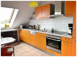 a kitchen with orange cabinets and a sink at Haus schöne Aussicht bei Chemnitz in Chemnitz