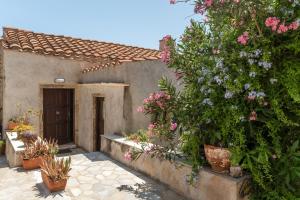 a house with a bunch of flowers in a yard at Casa Tradizionale Monemvasia in Monemvasia