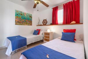 two beds in a room with red and blue at Seaside House With Heated Pool in Pájara +27 photos