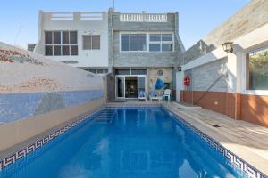 a swimming pool in front of a house at Seaside House With Heated Pool in Pájara