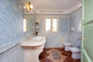 a bathroom with a sink and a toilet and a mirror at Appartamento Paguro in Cala Liberotto