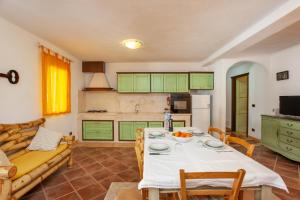 a living room with a table and a couch at Appartamento Paguro in Cala Liberotto +13 photos