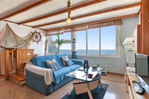 a living room with a blue couch and a table at Seaside House With Heated Pool in Pájara