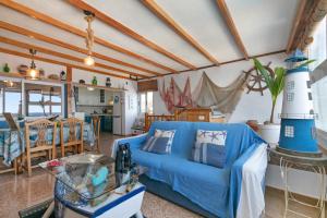 a living room with a blue couch and a table at Seaside House With Heated Pool in Pájara