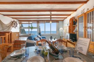 a living room with a dining room table with a view of the ocean at Seaside House With Heated Pool in Pájara