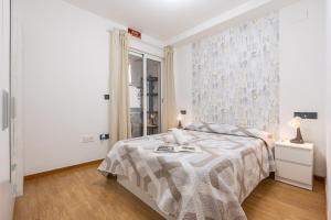a white bedroom with a bed and a window at Ágora Alhambra in Atarfe +18 photos