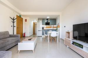 a living room with a couch and a tv at Ágora Alhambra in Atarfe