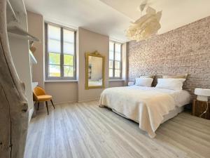 a bedroom with a large bed and a brick wall at Gîte Carcasso in Carcassonne