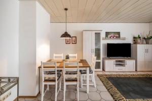 a dining room with a table and chairs and a television at Am Twistesee 1 Souterraint in Wetterburg