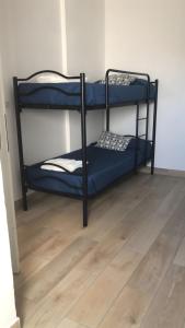 two bunk beds in a room with a wooden floor at Casa Nessi- Stanze in Platamona