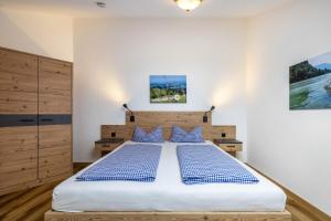 a bedroom with a large bed with blue pillows at Fewo Brünnstein - Zimmer 50 in Oberaudorf