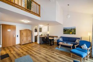 a living room with a blue couch and a table at Fewo Brünnstein - Zimmer 50 in Oberaudorf