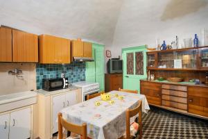 a kitchen with a table and a kitchen with green at Casa Gianni in Vallebona