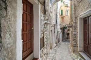 an alley in an old town with a wooden door at Casa Gianni in Vallebona