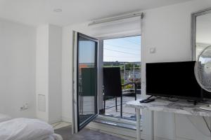 a living room with a television and a balcony at Luxusvilla Neubau 2 in Oberasbach