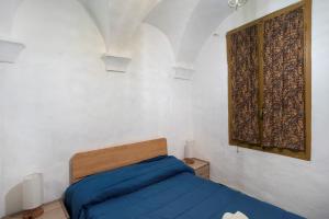 a bedroom with a blue bed and a window at Casa Gianni in Vallebona