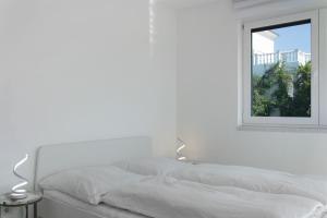 a white bed with a mirror on the wall at Luxusvilla Neubau 2 in Oberasbach