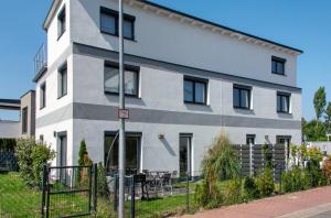 a white building with black windows on a street at Luxusvilla Neubau 2 in Oberasbach