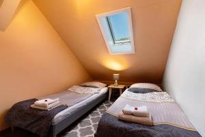 two twin beds in a room with a window at Ferienwohnung Das Nest in Schiltach
