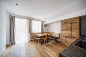 a kitchen and dining room with a wooden table at Sonnleiten Sterngucker 7 in Collepietra