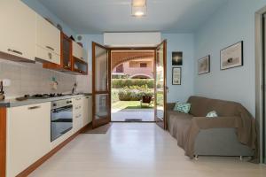 a kitchen and living room with a couch and a table at Residence Valle Fiorita in Piombino