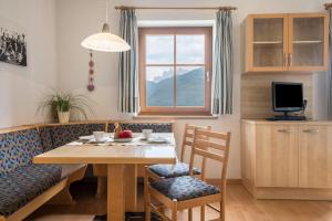 a living room with a table and chairs and a couch at Woehrmannhof Apt Spinnrad in Feldthurns