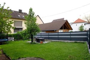 a fence in front of a house with a yard at Ferienwohnung Sink in Staufen im Breisgau
