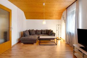 a living room with a couch and a tv at Ferienwohnung Sink in Staufen im Breisgau
