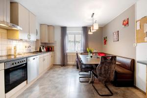 a kitchen with a table and a dining room at Ferienwohnung Sink in Staufen im Breisgau