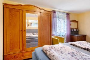 a bedroom with a large wooden cabinet with a mirror at Ferienwohnung Sink in Staufen im Breisgau