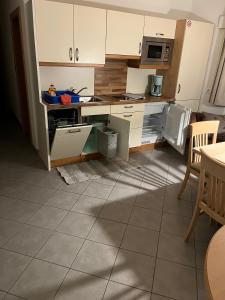 a kitchen with white cabinets and a stove top oven at App Sonne Nr 17 in Lutago +5 photos