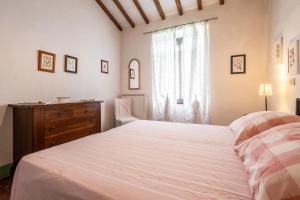 a bedroom with a bed and a dresser and a window at Appartamento Geranio in Radicofani +14 photos