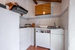 a white kitchen with a sink and a dishwasher at Appartamento Geranio in Radicofani