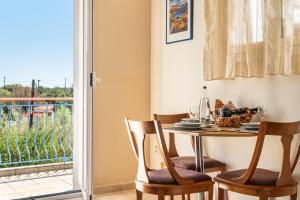 a dining room with a table and chairs and a balcony at Efrosyni apartment in Kefallonia +18 photos