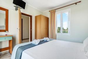 a bedroom with a white bed with towels on it at Efrosyni apartment in Kefallonia