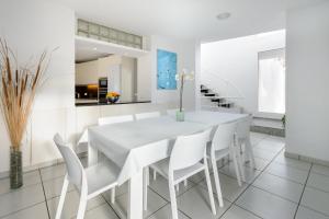 a white dining room with a white table and white chairs at Can Lluc in Nuestra Señora de Jesus