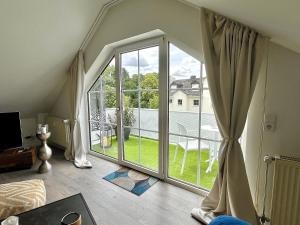 a room with a large window with a view of a patio at Ferienwohnung an der Aschaffaue in Aschaffenburg