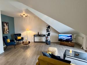a living room with a couch and a flat screen tv at Ferienwohnung an der Aschaffaue in Aschaffenburg