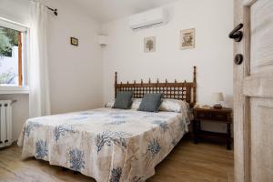 a bedroom with a bed with a blue and white comforter at Villa Amata in Arzachena +36 photos