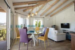 a dining room and living room with a table and chairs at Villa Amata in Arzachena