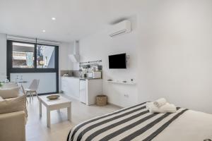 a bedroom with a bed and a living room at Apartamento Black and White 1 11 in Tarifa