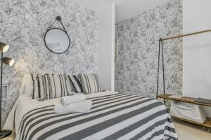 a bedroom with a bed with a mirror on the wall at Apartamento Black and White 1 11 in Tarifa +17 photos