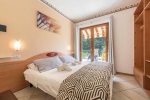 a bedroom with a bed and a large window at Residence Tatiana A2 in Tremosine Sul Garda