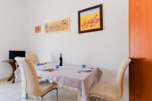 a dining room table with a white table cloth and chairs at La casetta 461 in Torre San Giovanni Ugento +15 photos