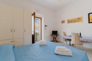 a bedroom with a blue bed with towels on it at La casetta 461 in Torre San Giovanni Ugento
